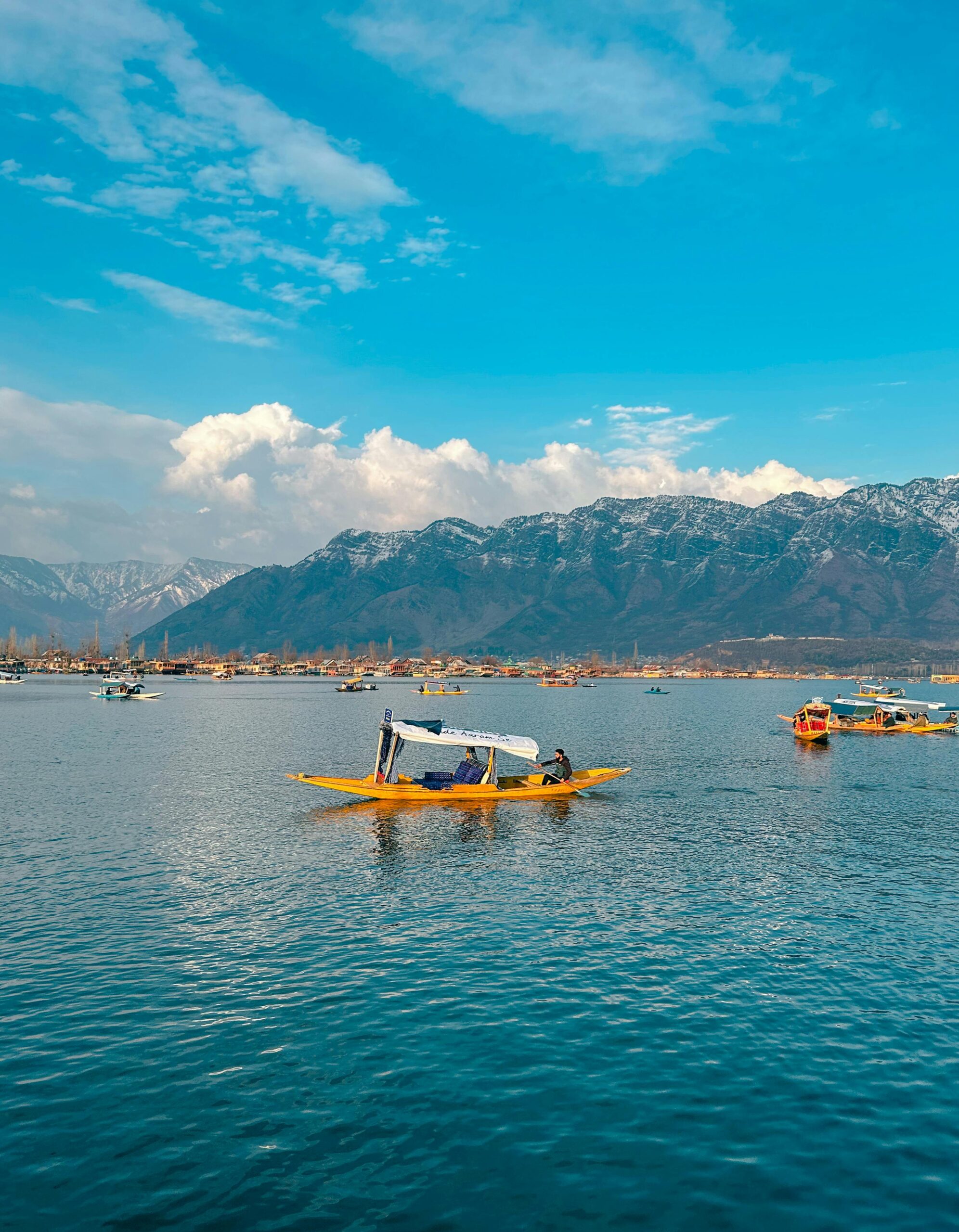 Beautiful Shikara boats on Dal Lake with a backdrop of the majestic Himalayas in Srinagar.